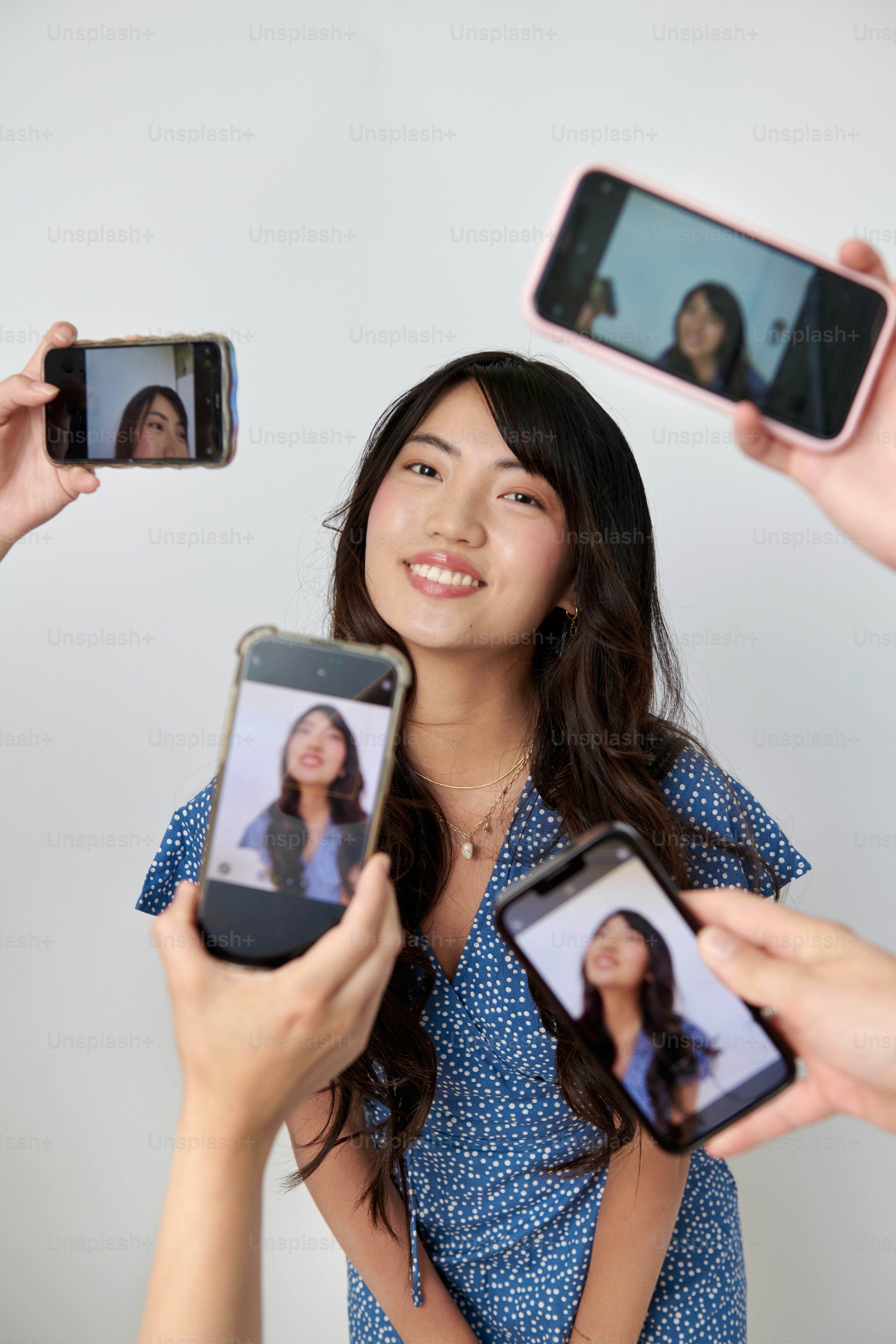 A group of people taking pictures with their cell phones